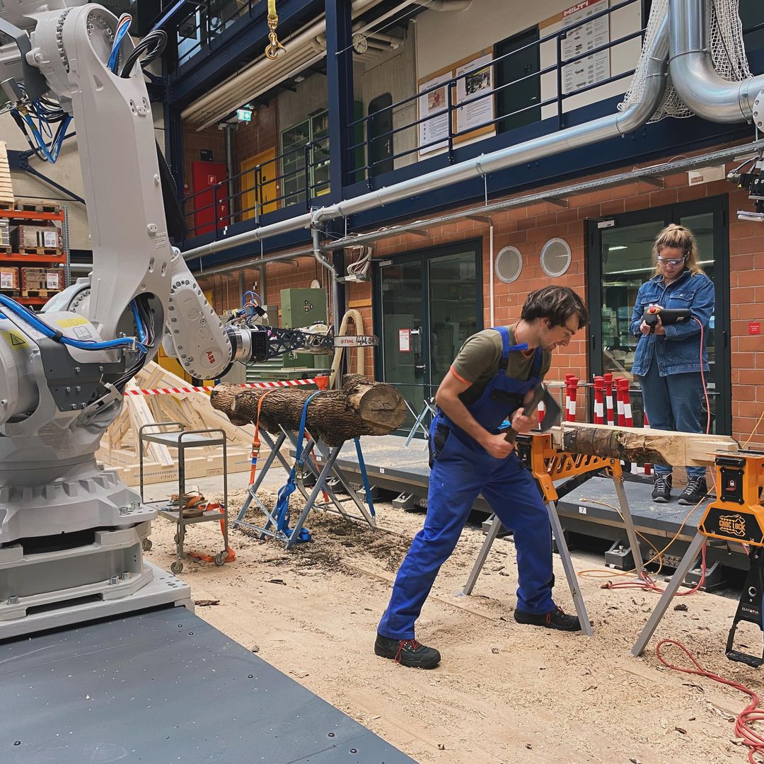 Alberto cutting wood and Eleni operating a robot